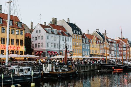 Row of traditional, colorful Danish row buildings along the canal at sunset in Copenhagen, Denmarkのeditorial素材