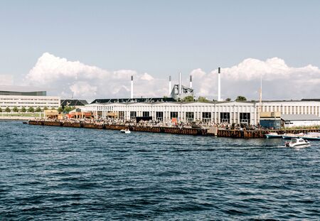 Crowds of people sitting by the waterfront at Food Market Papiroen, on a warm summer day.  Copenhagen, Denmarkのeditorial素材