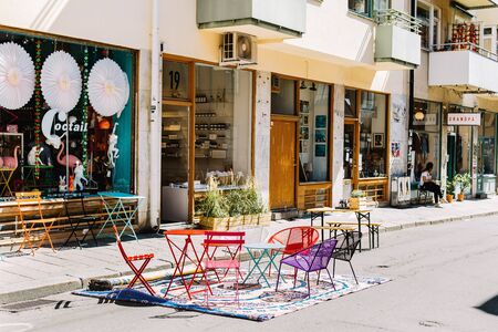 A row of stores in Gamla Brogatan with a colorful set of table and chairs on the street.  Stockholm, Swedenのeditorial素材