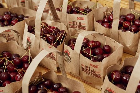 Boulder, Colorado - August 10th, 2019: Brown bags of organic local cherries for sale at a Farmers Market in Boulder.のeditorial素材