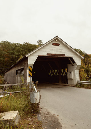 West Dummerston covered bridge surrounded by Fall foliage in the New England town of Dummerston,...