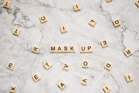 Make up word made of wooden blocks on white marble background with copy space
