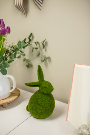Easter bunny with tulips and books on white wooden table.の写真素材