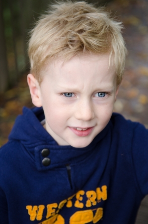 concerned looking blonde boy with blue eyes, outdoorsの写真素材