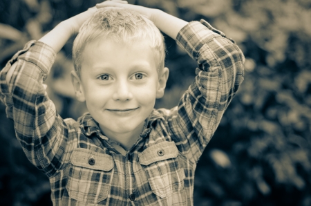 relieved happy blonde kid with hands on head monochromeの写真素材