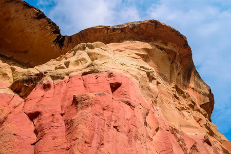 The towering cliff and overhanging ledge of Mushroom Rock, a colorful sandstone formation in the Golden Gate Highlands National Park in South Africa.の写真素材