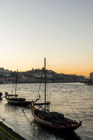 Typical Porto boats on the Douro river, with the sunset in the background.のeditorial素材