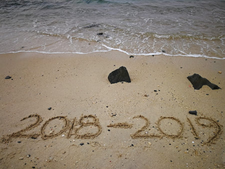 Happy new year concept, 2018 to 2019 written in the sand on a beach