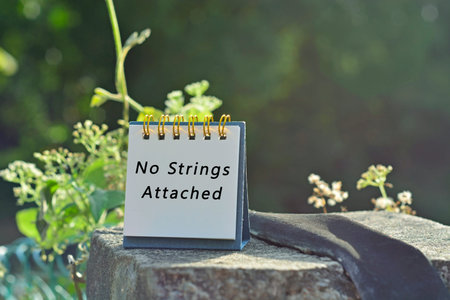 No strings attached text written on white note with green blurred background
