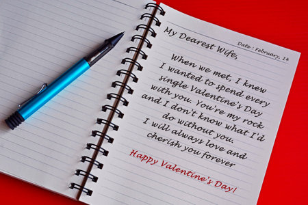 Text on white notepad with red background. Top view and Valentine's day conceptの写真素材