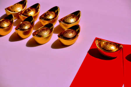 Chinese New Year Spring festival decorations red packet and gold ingots on pink background. Chinese translation : good fortune, good luck, wealth, and money flow.の写真素材