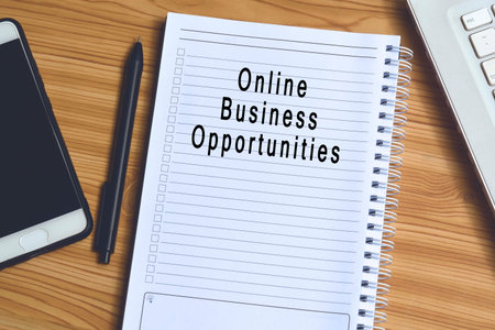 Online business opportunities label on notepad with laptop and smartphone on wooden table. Business conceptの写真素材