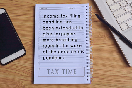 Text on notepad with laptop and smartphone on wooden tableの写真素材