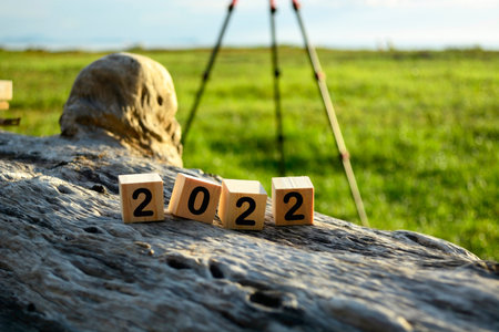 2022 wooden cube block on old tree stump with blurred background