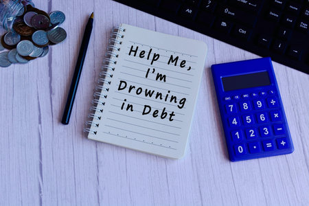 Text on notepad with calculator, pen, glass jar with coins and keyboard - Help me I am drowning in...