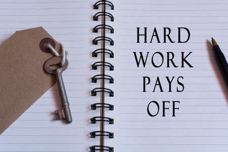 Text written on notebook with house key - Hard work pays offの写真素材