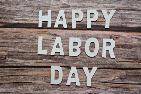 Happy labor day text on wooden table backgroundの写真素材