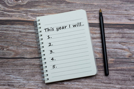 Text on notebook with pen on wooden desk