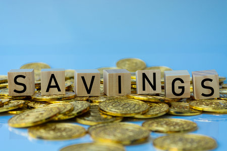 Savings text on wood block with a pile of coins