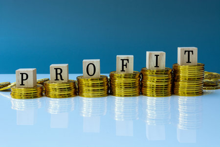 Profit text on wood block with a pile of coins