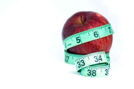 Blurred red apple with measuring tape isolated on whiteの写真素材