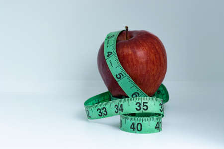 Blurred red apple with measuring tape isolated on whiteの写真素材