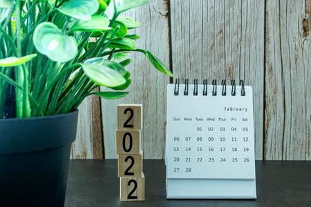 White February 2022 calendar with wooden block. New Year Concept