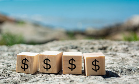 Dollar sign on wooden block with blurred background of blue ocean. Finance conceptの写真素材