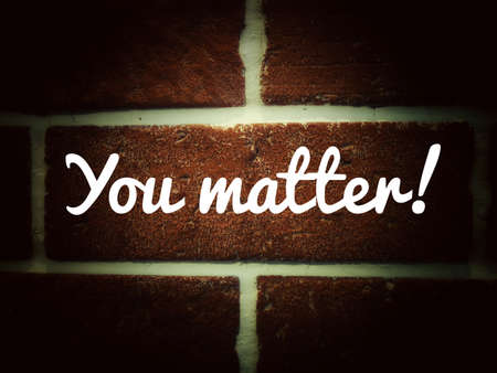 Texture of an old red brick wall with cement joints with text. You matter.の写真素材