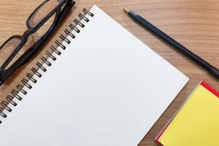 Notepad with yellow note and study glasses. Flat lay. Directly aboveの写真素材