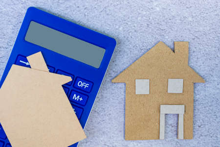 Calculator with paper house model. Home insurance, mortgage and investment concept.の写真素材
