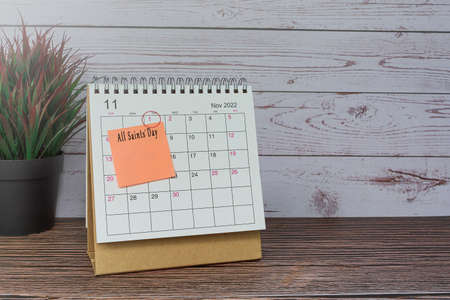 November 2022 calendar on wooden desk with date circle and text on sticky note.の写真素材