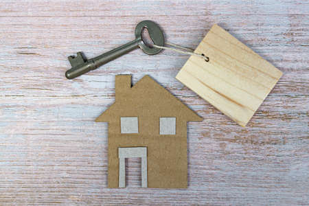 House model and key on wooden desk. Directly above. Flat lay for text.の写真素材
