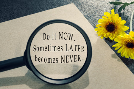 Motivational quote on brown envelope with sunflowers on wooden desk - Do it now, sometimes later...