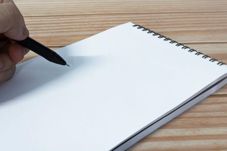 Hand with pen writing notebook on office desk table with. Copy space. Business concept.