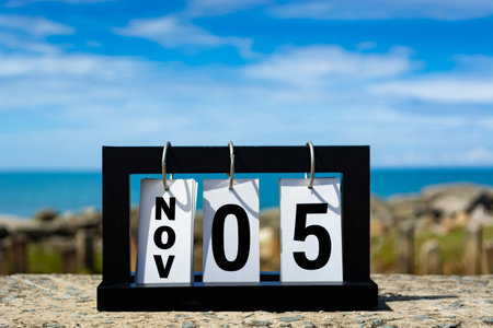 Nov 05 calendar date text on wooden frame with blurred background of ocean.の写真素材