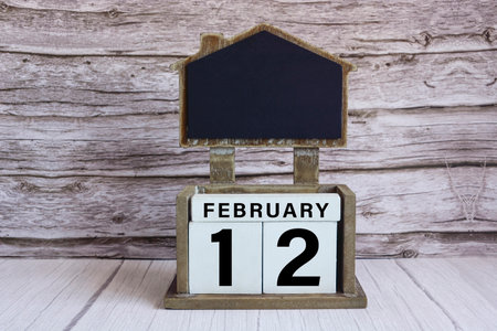 Chalkboard with calendar date on white cube block on wooden table.の写真素材