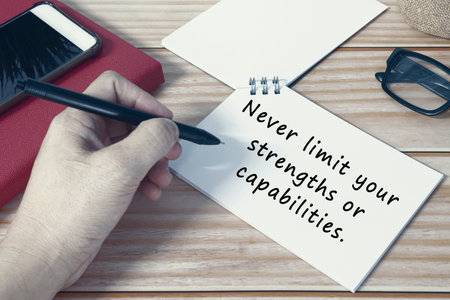 Motivational quote on notepad - Never limit your strengths or capabilities.の写真素材