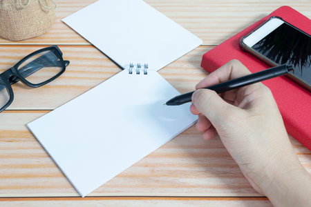 Businessman hands with pen writing notebook on office desk. Copy space. Business concept.の写真素材