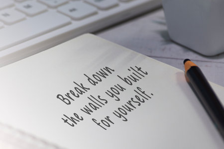 Motivational and inspirational quote on notepad - Break down the walls you built for yourself.の写真素材