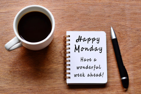 Happy monday with motivation quote on notebook with coffee cup and pen on wooden desk.の写真素材