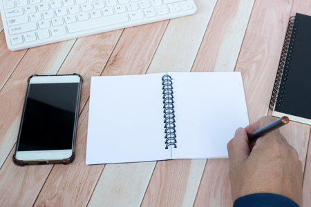 Businessman hands with pen writing notebook on office desk table. Copy space. Business concept.の写真素材