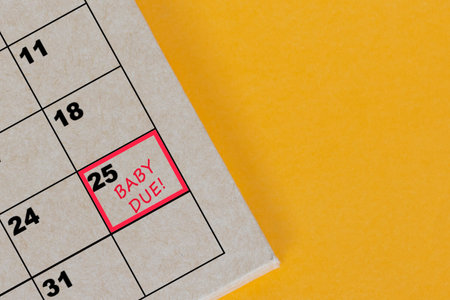 Red mark on the calendar at 25 for reminder of baby due date. Pregnancy concept.の写真素材