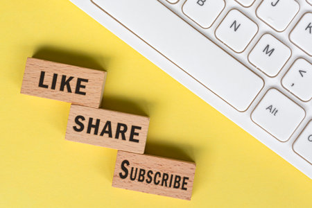 Like Share Subscribe words on wooden blocks with keyboard. Social media marketing concept background.の写真素材