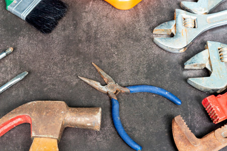 Old construction tools on concrete floor. Industry tools, home renovation, maintenance and repairing...