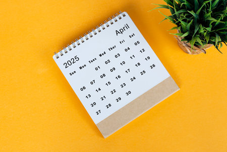 April 2025 desk calendar on yellow background. Directly above. Flat layの写真素材