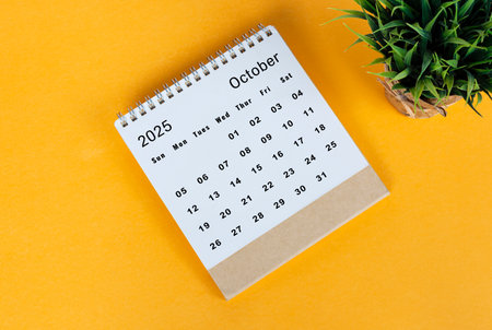 October 2025 desk calendar on yellow background. Directly above. Flat layの写真素材