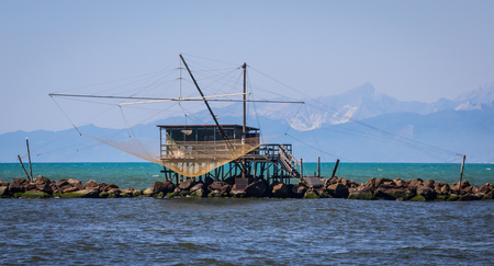 Fishing shack to trawl the estuary, with mountains behindの写真素材