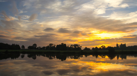 Early morning landscape, sky reflecting in the lake looking towards the rugby pitch.の写真素材