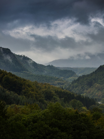 Storm clearing, the end of storm clouds moving over the forests and mountainsの写真素材